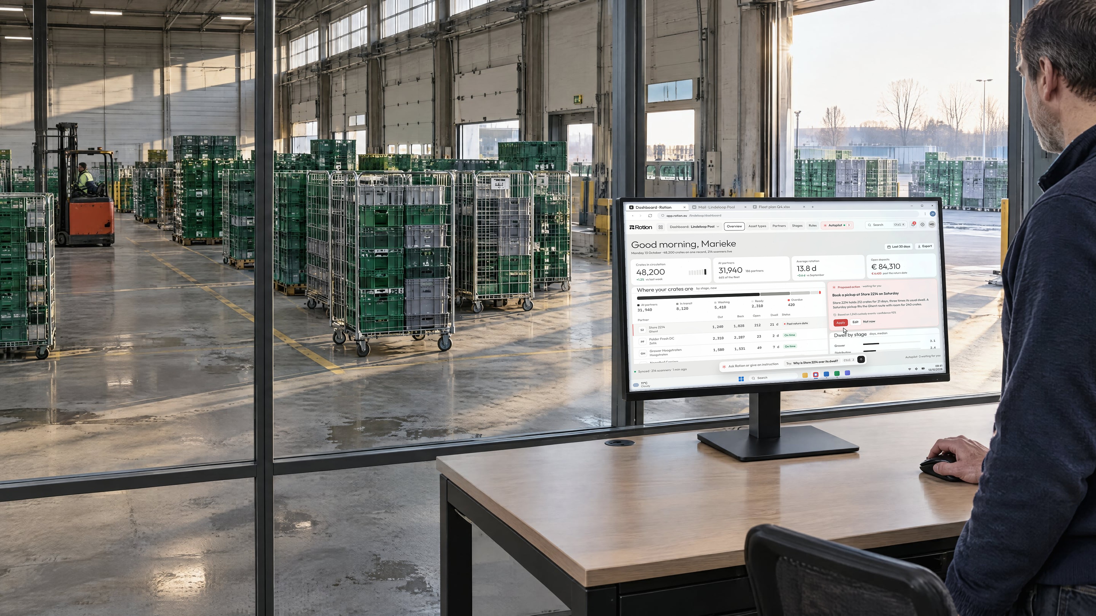 An operations manager at a desk beside a cross-dock, the monitor showing the Rotion dashboard with crates per stage and a pickup proposal from Autopilot